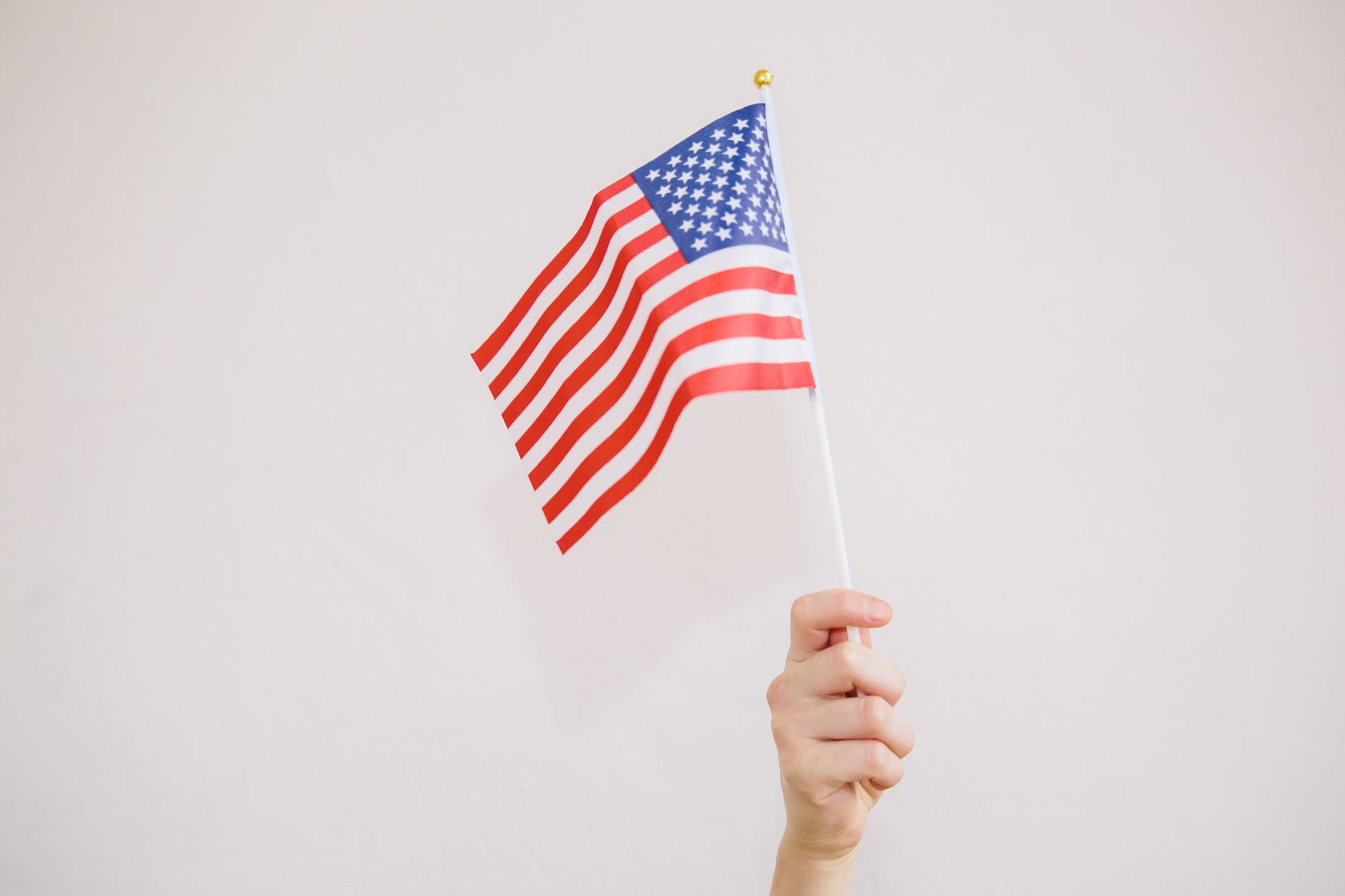 Hands holding an American flag, illustrative image